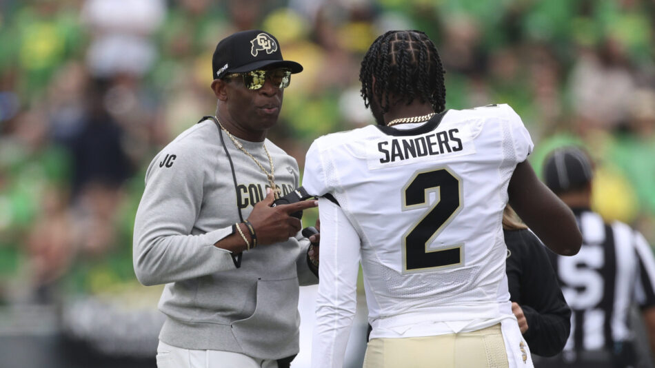 Colorado head coach Deion Sanders talks with his son and quarterback Shedeur Sanders during the fir...