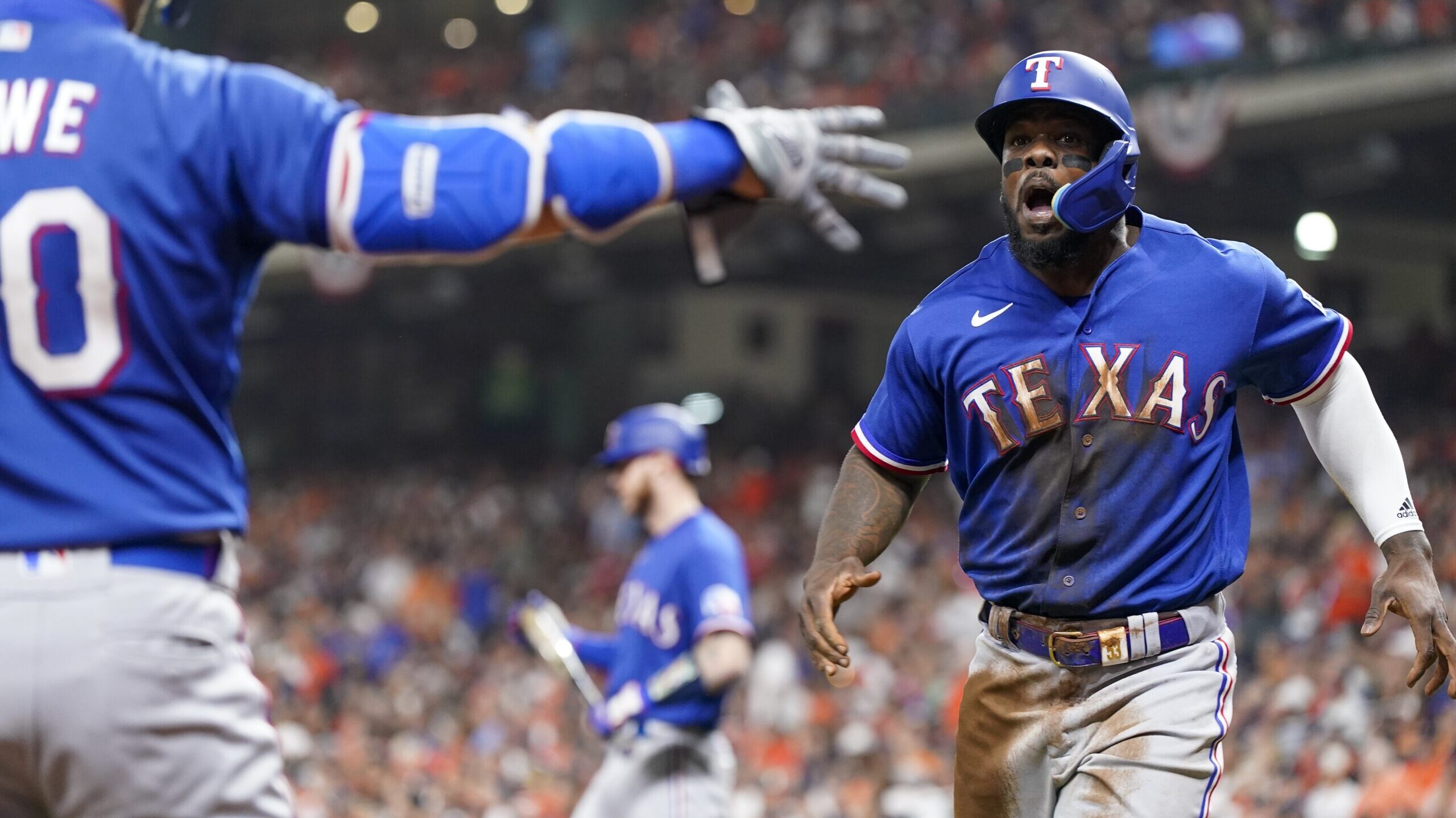 Texas Rangers' Adolis Garcia celebrates after scoring during the first inning of Game 6 of the base...