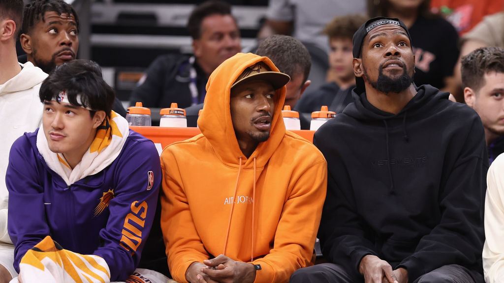 Yuta Watanabe #18, Bradley Beal #3 and Kevin Durant #35 of the Phoenix Suns watch from the bench du...