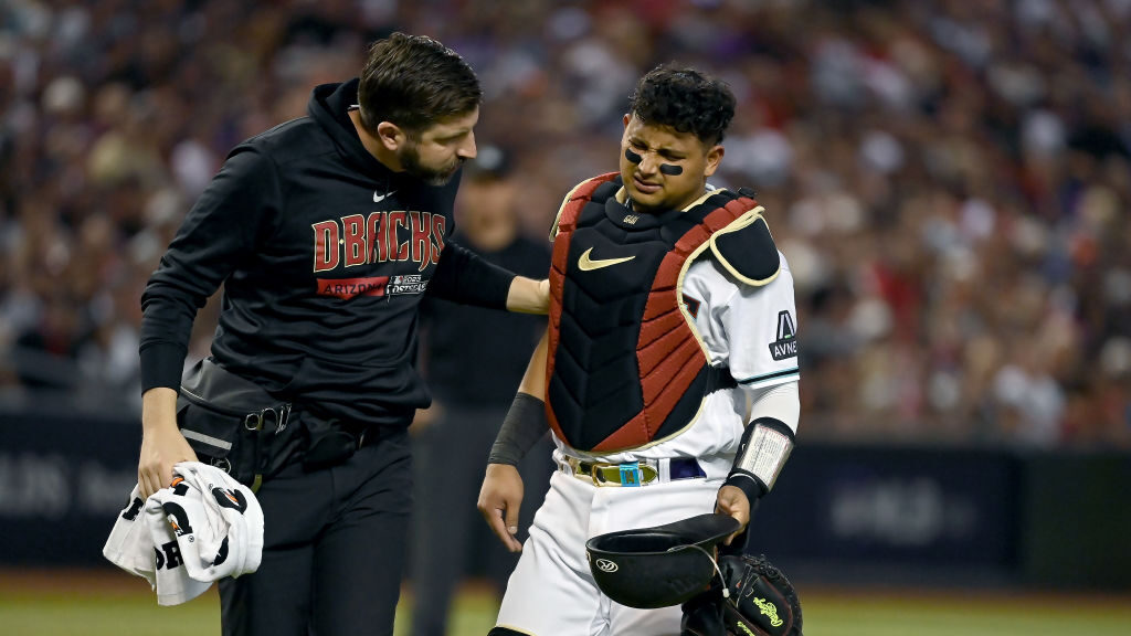 Gabriel Moreno #14 of the Arizona Diamondbacks is attended to after being injured in the fifth inni...