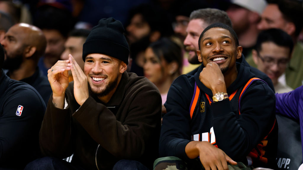Devin Booker #1 and Bradley Beal #3 of the Phoenix Suns follow the action from the bench during the...