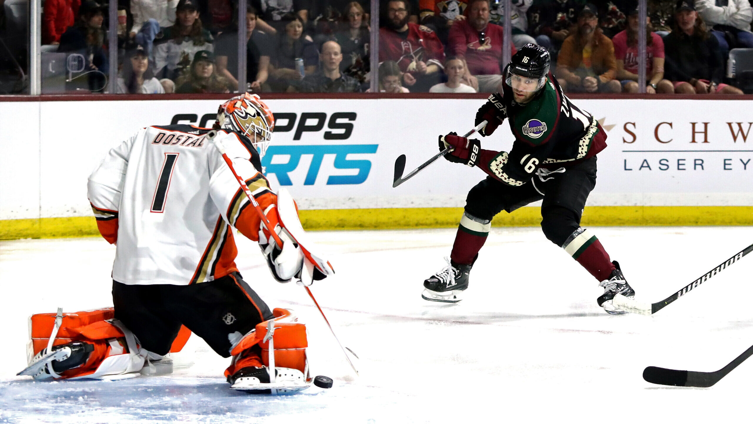 Jason Zucker #16 of the Arizona Coyotes takes a shot against Lukas Dostal #1 of the Anaheim Ducks d...