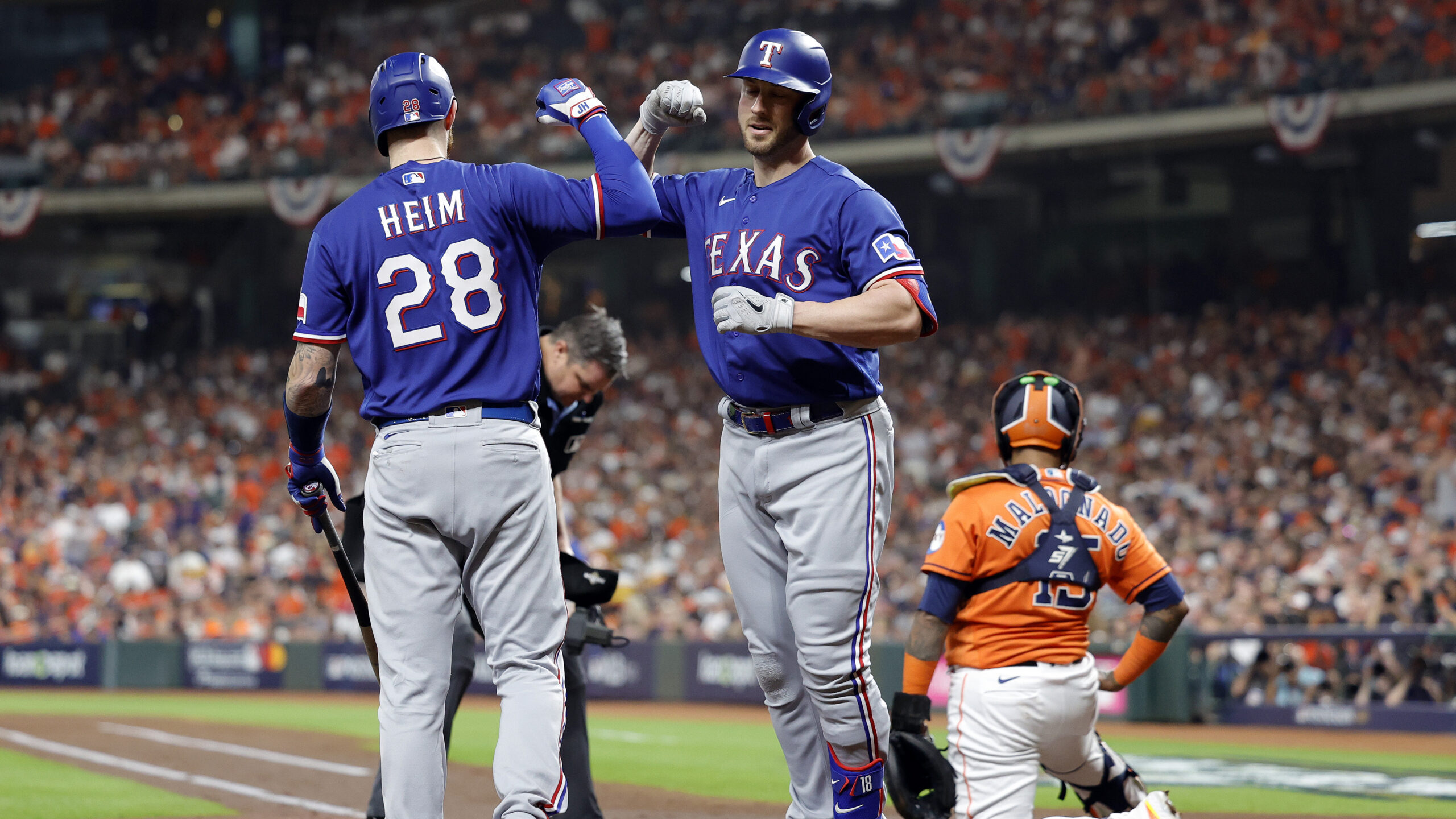 Mitch Garver #18 of the Texas Rangers celebrates with Jonah Heim #28 after hitting a solo home run ...