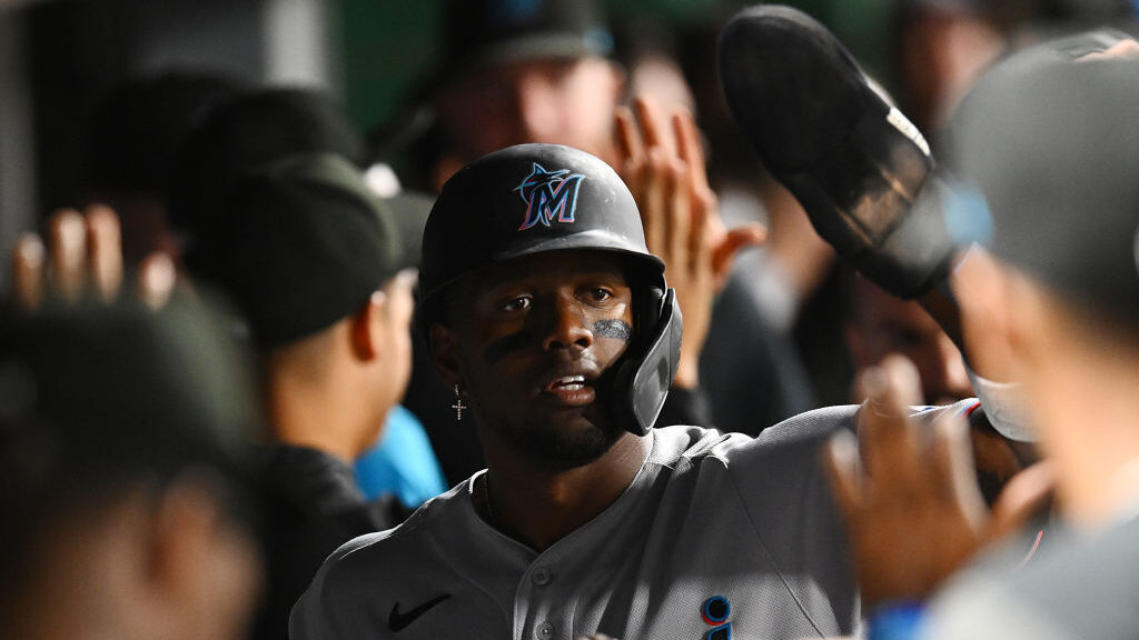 Jorge Soler #12 of the Miami Marlins celebrates with teammates in the dugout after scoring during t...