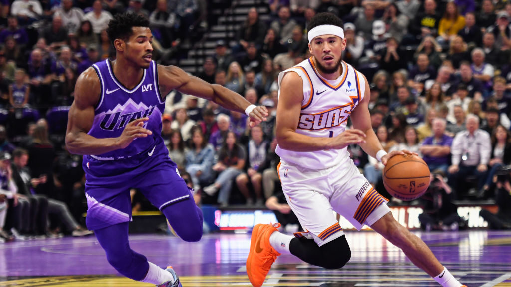 Devin Booker #1 of the Phoenix Suns drives past Ochai Agbaji #30 of the Utah Jazz during the first ...