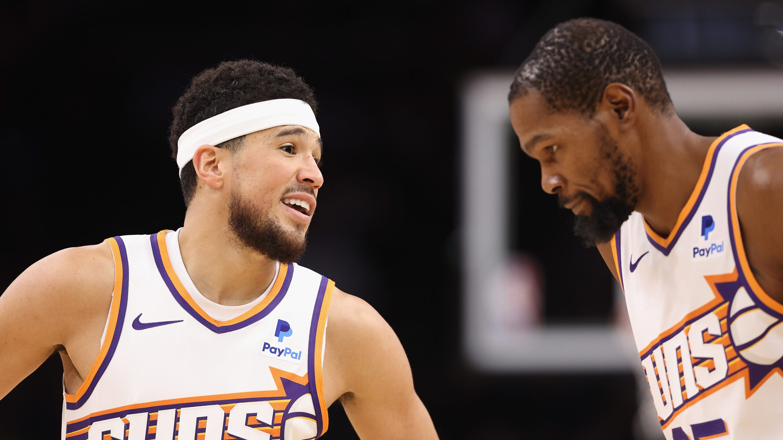 Devin Booker #1 of the Phoenix Suns talks with Kevin Durant #35 during the second half of the NBA g...
