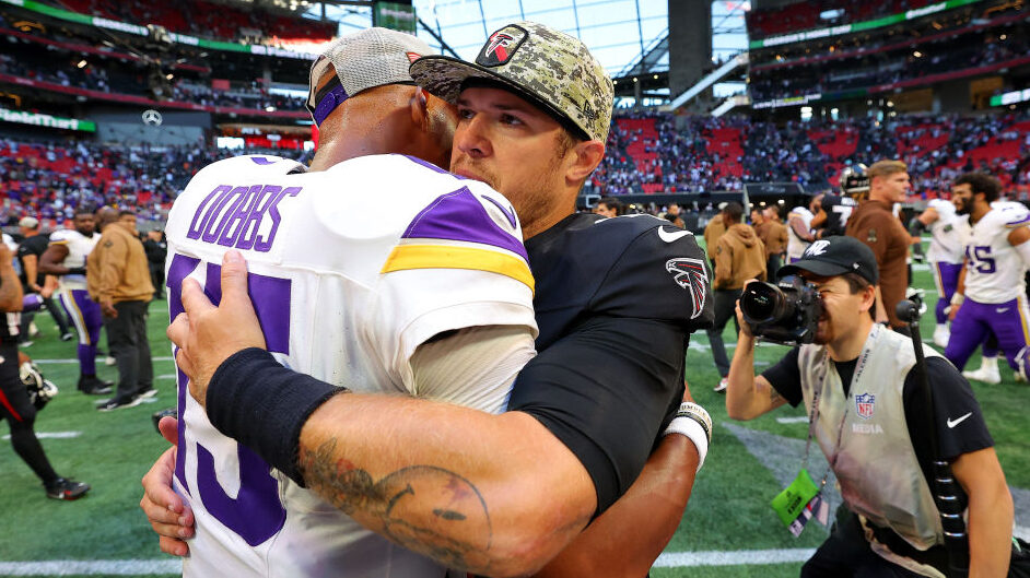 Taylor Heinicke of the Falcons hugs Joshua Dobbs of the Vikings...