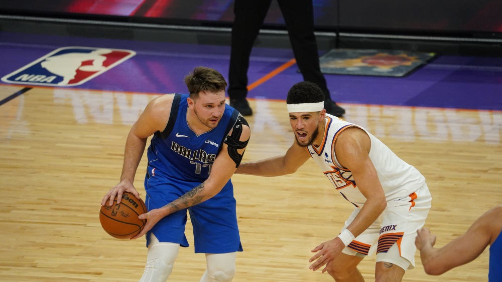 Suns guard Devin Booker defending Mavericks guard Luka Doncic (Jeremy Schnell/Arizona Sports)...