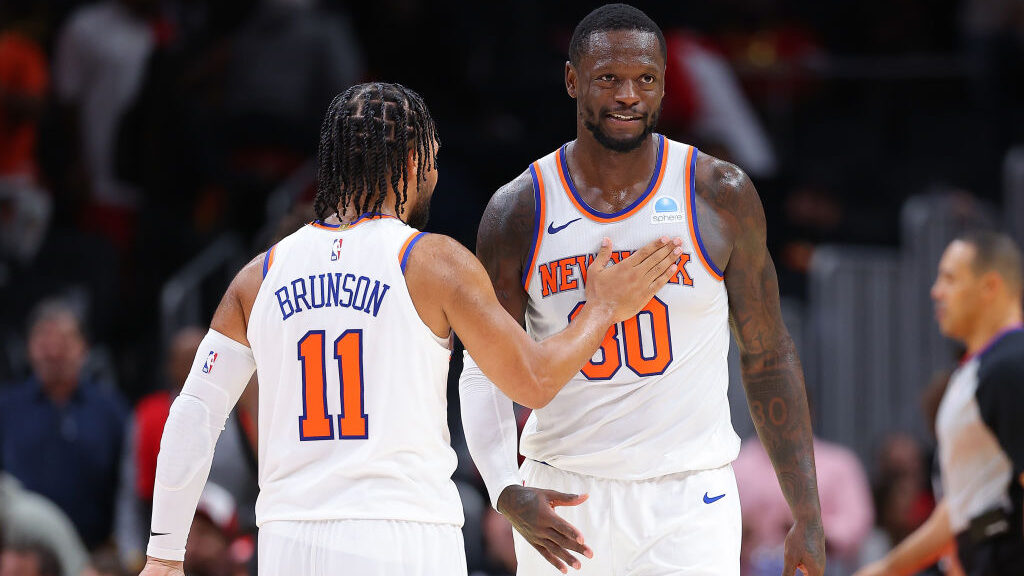 Julius Randle #30 of the New York Knicks reacts with Jalen Brunson #11 after grabbing a rebound and...