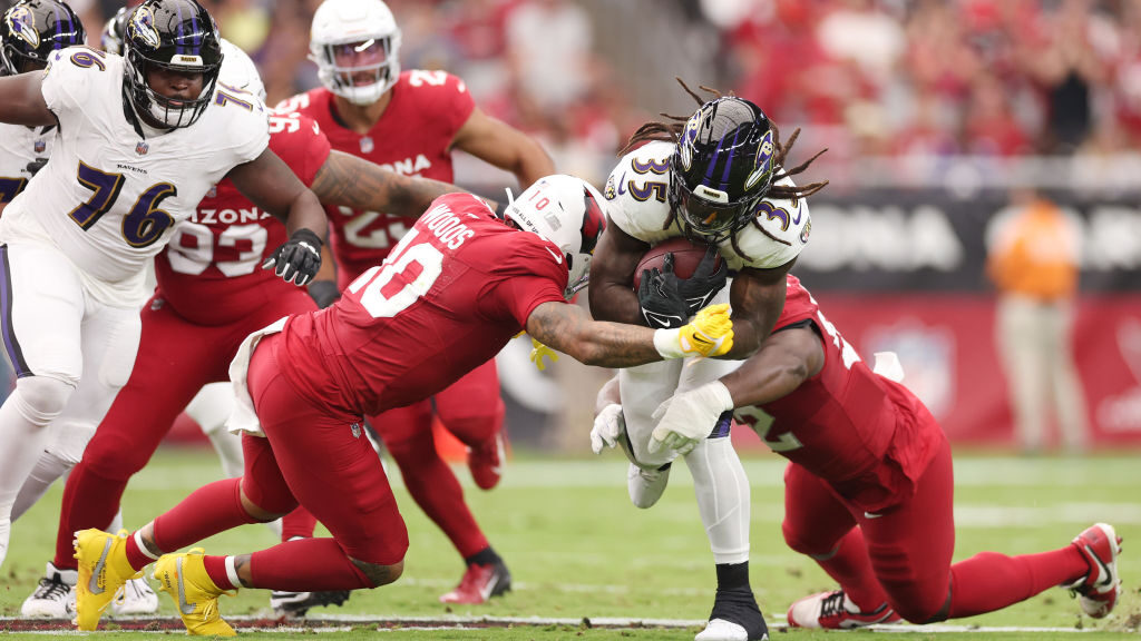 Josh Woods #10 of the Arizona Cardinals tackles Gus Edwards #35 of the Baltimore Ravens during the ...
