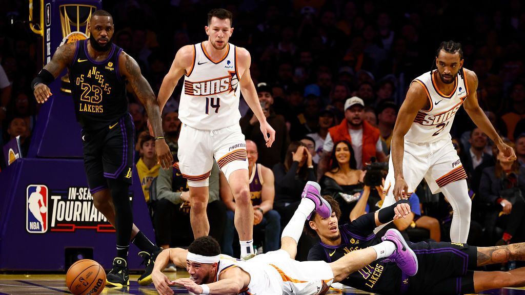 Devin Booker #1 of the Phoenix Suns dives for the ball against Jaxson Hayes #11 of the Los Angeles ...