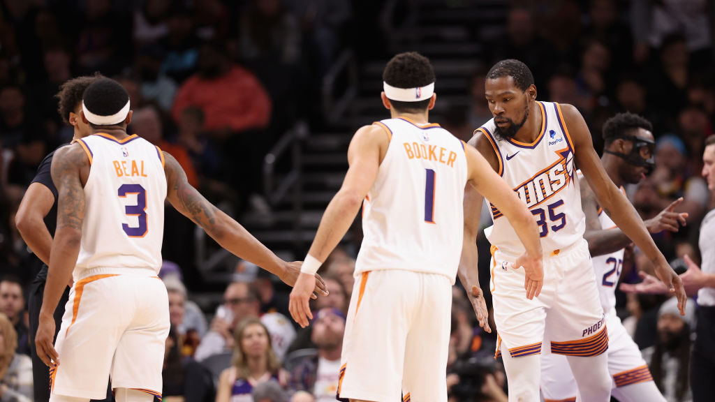 Kevin Durant #35 of the Phoenix Suns high fives Bradley Beal #3 and Devin Booker #1 during the seco...