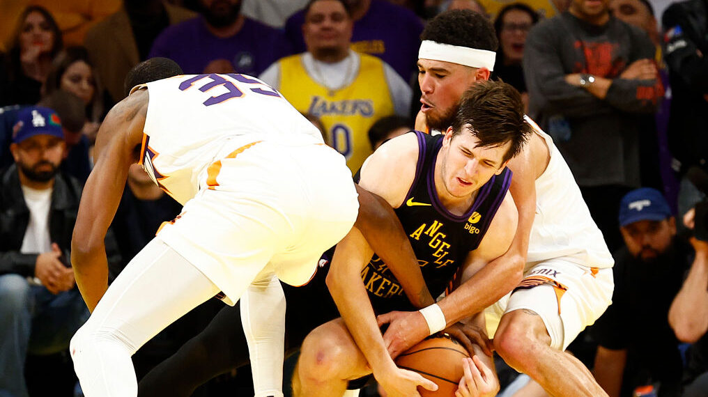 Austin Reaves of the Lakers is trapped by Devin Booker and Kevin Durant of the Suns...