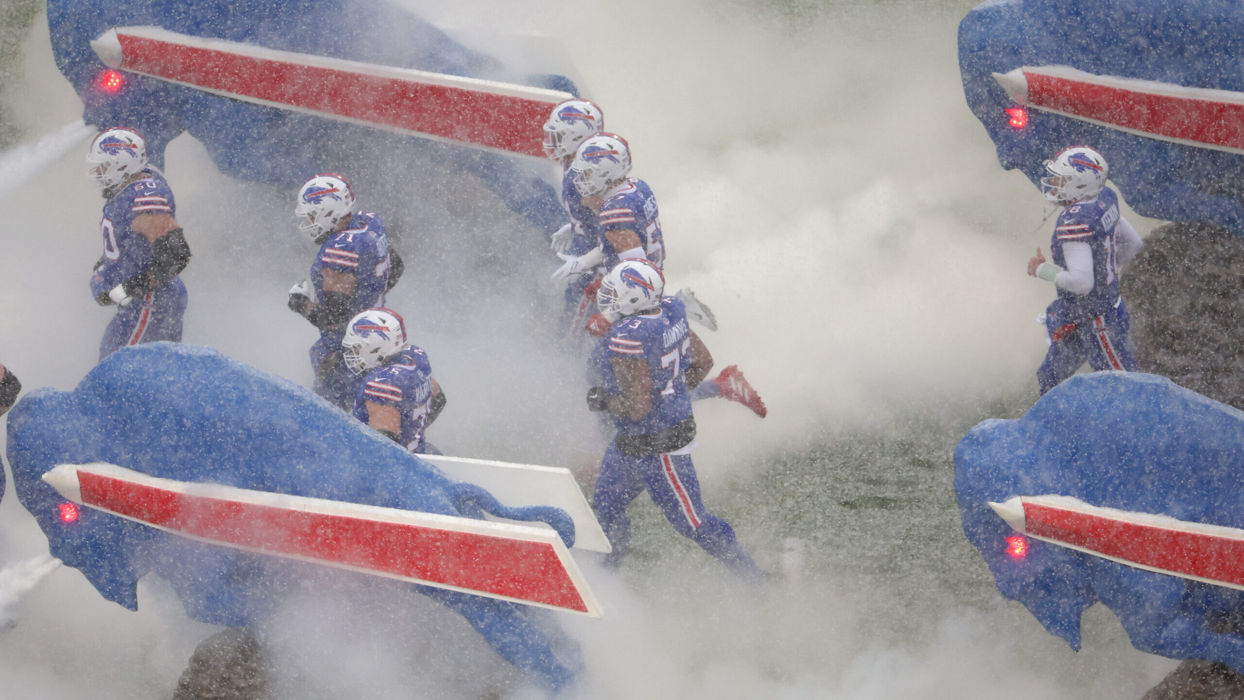 The Buffalo Bills take the field as snow falls in the AFC Divisional Playoff game against the Cinci...