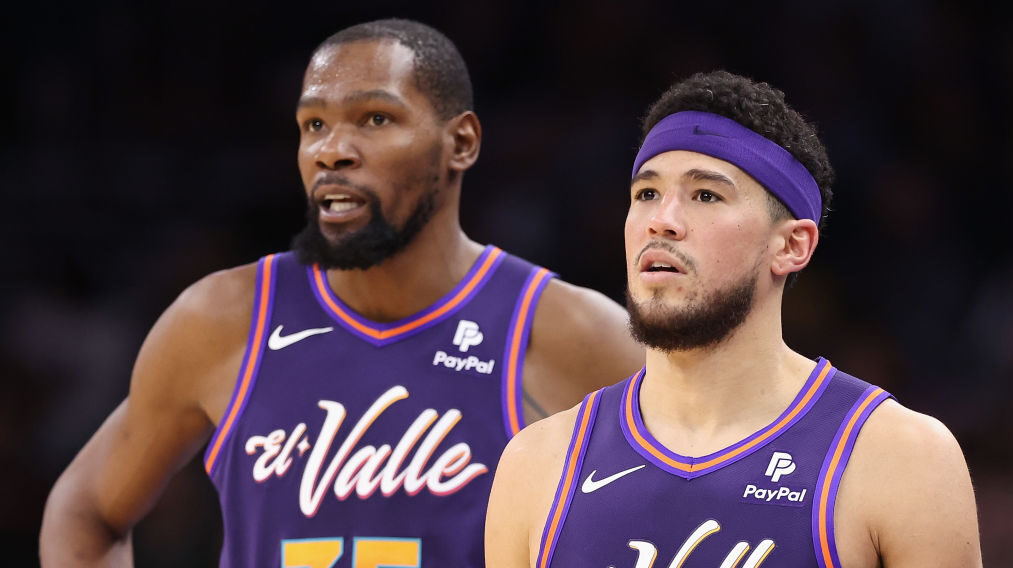 Kevin Durant and Devin Booker look on...