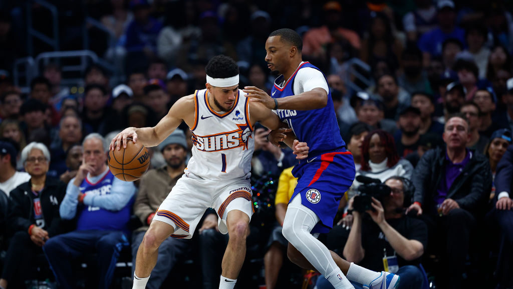Devin Booker #1 of the Phoenix Suns controls the ball against Norman Powell #24 of the LA Clippers ...