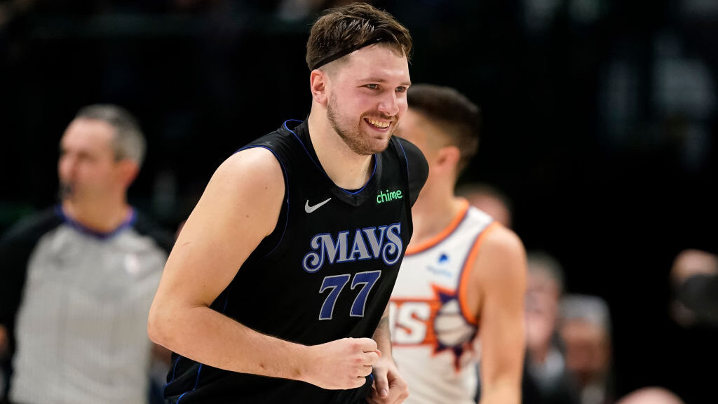 Luka Doncic #77 of the Dallas Mavericks smiles as he runs up the court after a scoring during the f...