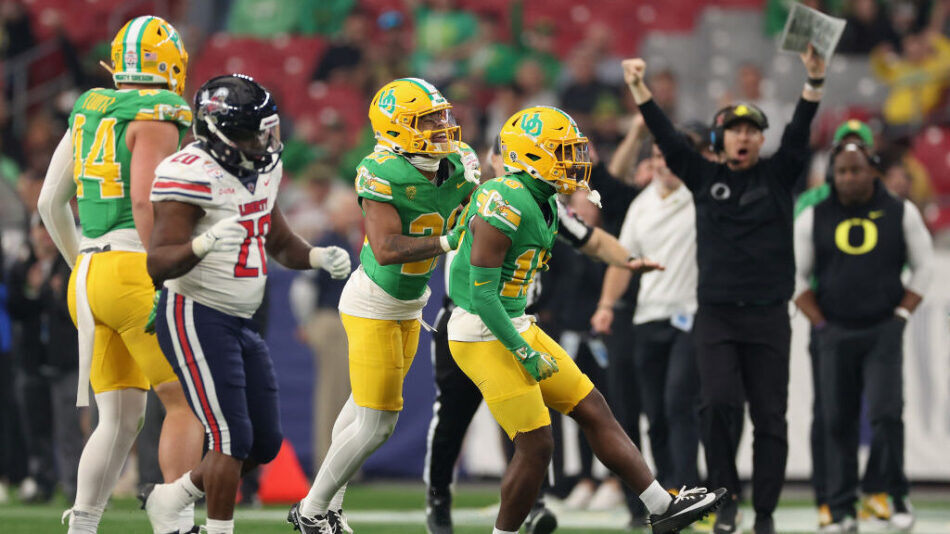 Defensive back Rodrick Pleasant #16 of the Oregon Ducks celebrates with Cole Martin #21after recove...