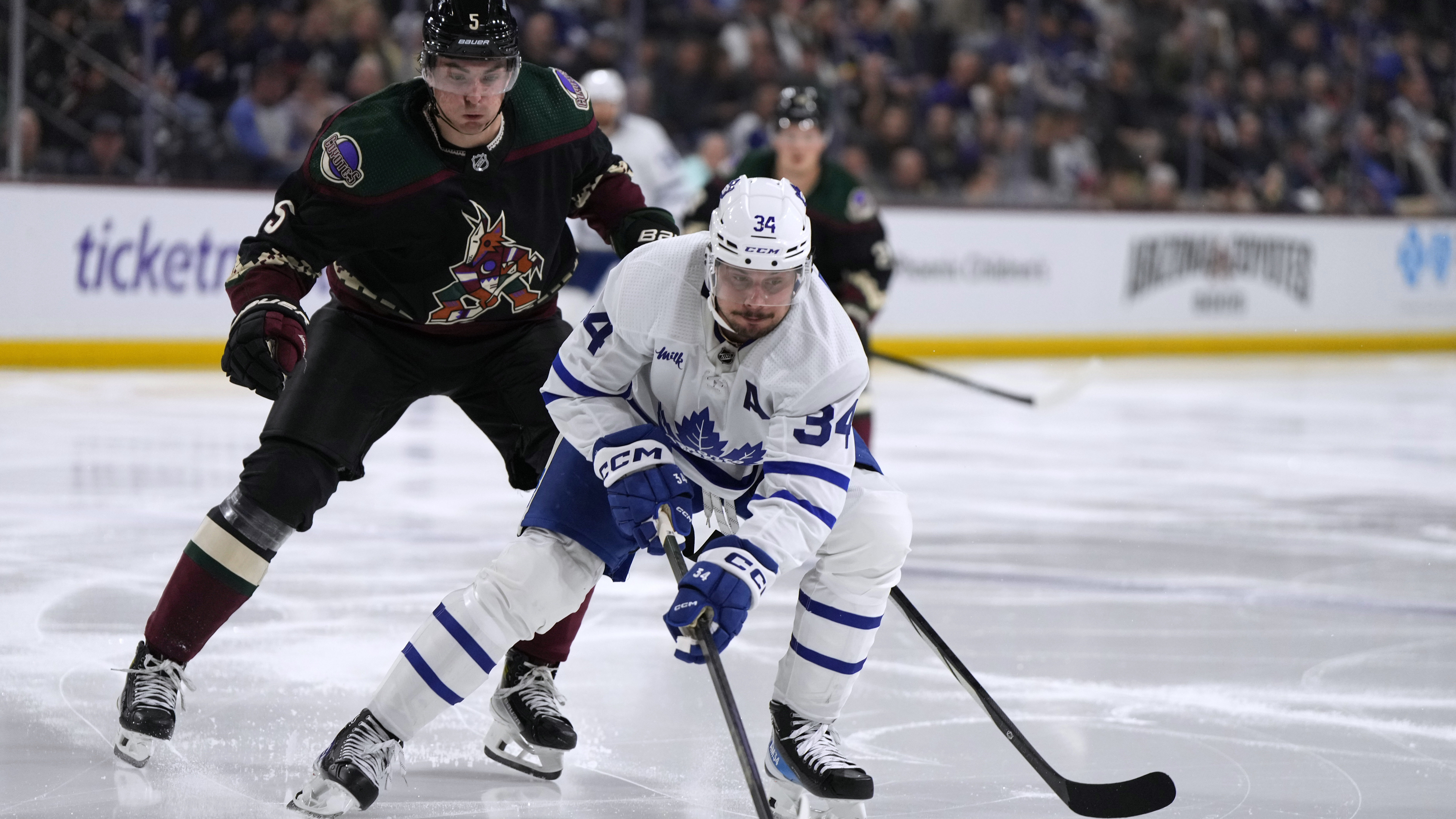 Toronto Maple Leafs center Auston Matthews (34) carries the puck in front of Arizona Coyotes defens...