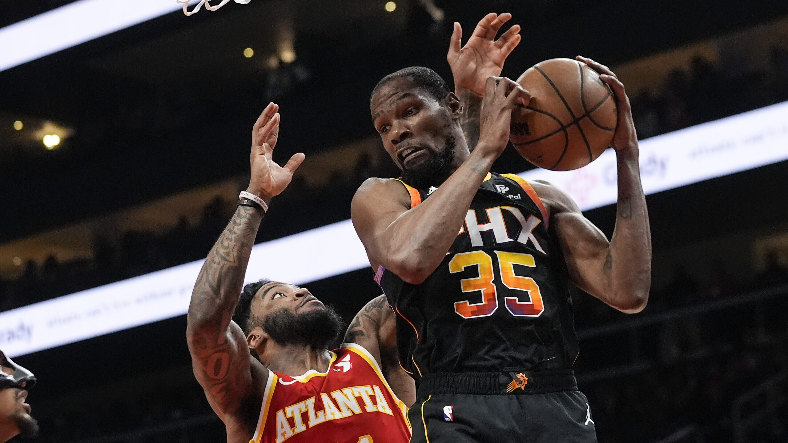 Phoenix Suns forward Kevin Durant (35) grabs a rebound in front of Atlanta Hawks forward Saddiq Bey...