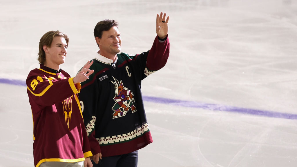 ASU hockey player Josh Doan and father Shane Doan wave to fans before the ceremonial first puck to ...