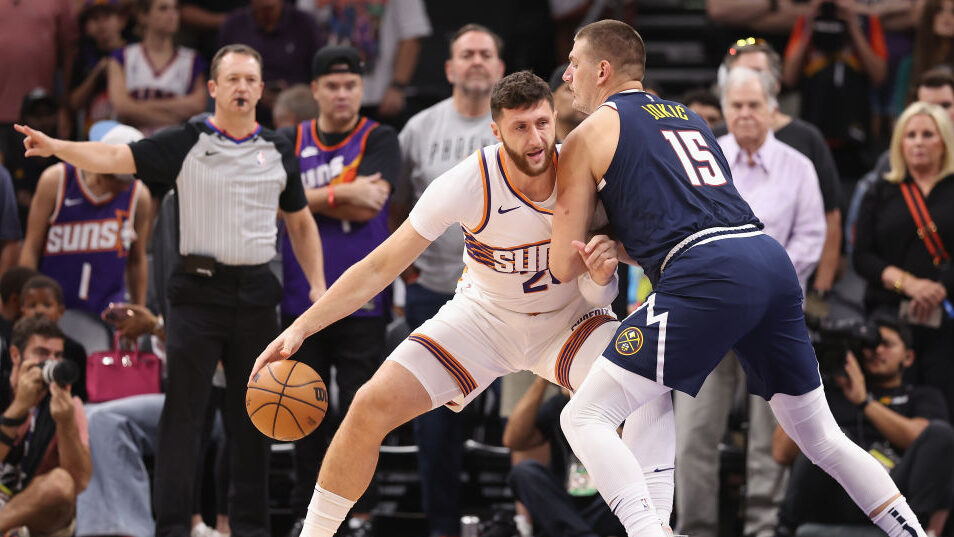 The Suns' Jusuf Nurkic posts up Nikola Jokic of the Nuggets...
