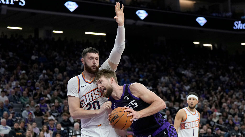 Domantas Sabonis #10 of the Sacramento Kings drives against Jusuf Nurkic #20 of the Phoenix Suns du...