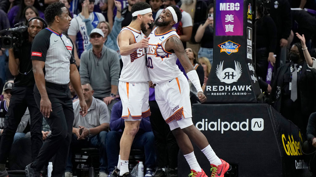 Royce O'Neale #00 and Devin Booker #1 of the Phoenix Suns celebrate defeating the Sacramento Kings ...