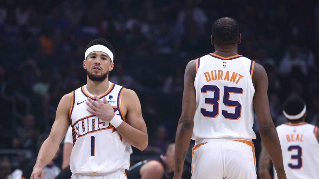 Devin Booker #1 of the Phoenix Suns reacts as he walks past Kevin Durant #35 during the first half ...