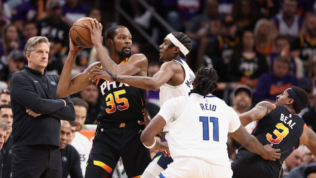 Kevin Durant #35 of the Phoenix Suns handles the ball under pressure from Jaden McDaniels #3 of the...