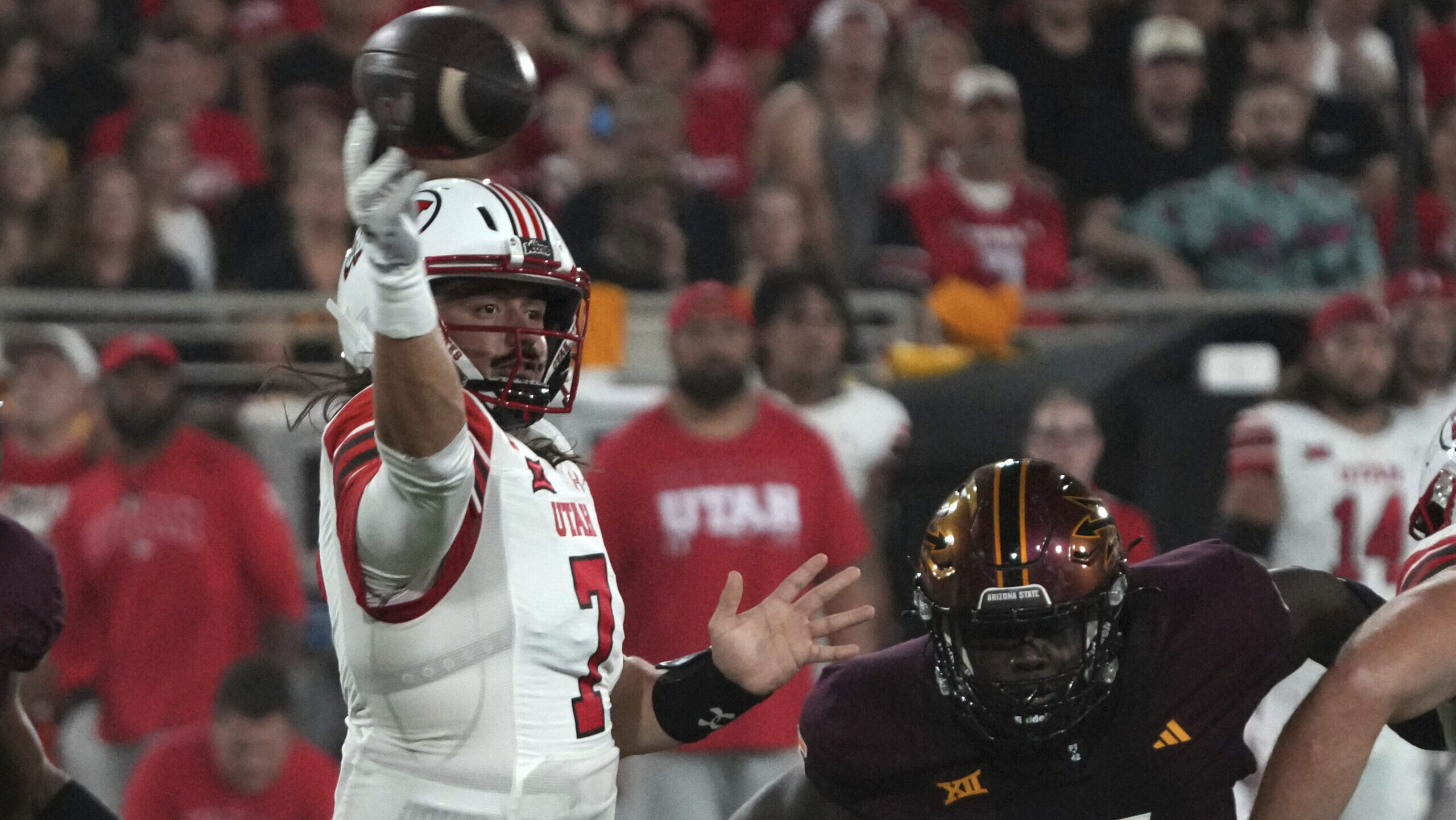 Utah quarterback Cameron Rising throws down field away from Arizona State defensive lineman Jeff Cl...