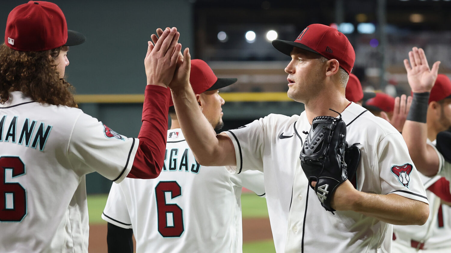 PHOENIX, ARIZONA - MARCH 31: Relief pitcher Paul Sewald #32 of the Arizona Diamondbacks high fives ...