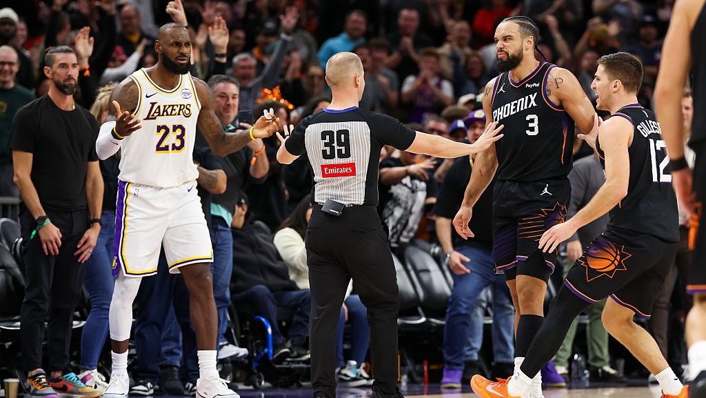 PHOENIX, ARIZONA - DECEMBER 14: An official comes between Lebron James #23 of the Los Angeles Laker...