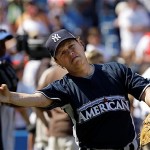 Actor Billy Crystal tosses a softball as he warms up for the All-Star Legends & Celebrity softball game at Yankee Stadium in New York, Sunday.