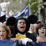 Protesters dressed as Disney characters, from left, Lori Condinus, Eric Zuniga and Angela Wilhite lead a march from the Paradise Pier Hotel to the main entrance of Disneyland during a demonstration protesting Disney's treatment of hotel workers in Anaheim, Calif., on Thursday, Aug. 14, 2008. (AP Photo/Carlos Delgado)