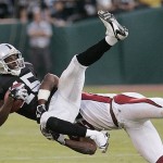 Oakland Raiders wide receiver Johnnie Lee Higgins (15) is tackled by Arizona Cardinals safety Adrian Wilson (24) in the second quarter of their preseason football game in Oakland, Calif., Saturday, Aug. 23, 2008. (AP Photo/Paul Sakuma)