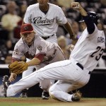 Arizona Diamondbacks third baseman Mark Reynolds, left, tries to make a diving tag on San Diego Padres' Adrian Gonzalez who is safe advancing to third on a fly ball to center field in the eighth inning of a baseball game Monday Aug. 25, 2008 in San Diego. (AP Photo/Lenny Ignelzi)