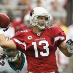 Arizona Cardinals' Kurt Warner (13) looks to pass the ball as Miami Dolphins' Channing Crowder (52) closes in late in the second quarter of a football game Sunday, Sept. 14, 2008, in Glendale, Ariz. The Cardinals defeated the Dolphins 31-10. (AP Photo/Ross D. Franklin)