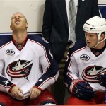 Columbus Blue Jackets' Jiri Novotny, left, of the Czech Republic, grimaces on the bench after being checked by Phoenix Coyotes' Shane Doan as Blue Jackets' Derek Dorsett, right, checks on his teammate in the third period of an NHL hockey game Saturday, Oct. 11, 2008, in Glendale, Ariz. The Coyotes defeated the Blue Jackets 3-1. (AP Photo/Ross D. Franklin)
