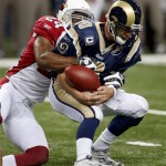 St. Louis Rams quarterback Marc Bulger, right, fumbles the ball as he is sacked by Arizona Cardinals safety Adrian Wilson for a nine-yard loss during the second quarter of an NFL football game Sunday, Nov. 2, 2008, in St. Louis. The Cardinals recovered the fumble. (AP Photo/Tom Gannam)