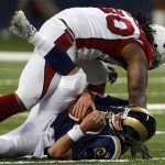 St. Louis Rams quarterback Marc Bulger, bottom, is sacked for a seven-yard loss by Arizona Cardinals defensive tackle Darnell Dockett during the second quarter of an NFL football game Sunday, Nov. 2, 2008, in St. Louis. (AP Photo/Tom Gannam)