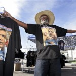 Aziz Muhammad holds up new shirts marking President-elect Barack Obama's election victory, for sale on a street corner in Oakland, Calif., Wednesday, Nov. 5, 2008. (AP Photo/Paul Sakuma)