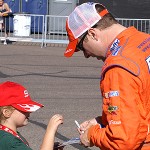 NASCAR Nationwide Series driver Eric McClure signs an autograph for a young fan. (Adam Green/Sports620 KTAR)