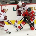 Chicago Blackhawks' Jonathan Toews (19) tries to keep the puck away from Phoenix Coyotes' Kurt Sauer (44) and Martin Hanzal (11), of the Czech Republic, in the first period of an NHL hockey game Tuesday, Nov. 18, 2008 in Glendale, Ariz. (AP Photo/Ross D. Franklin)