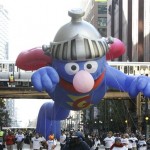 The Super Grover helium balloon rises out from under the elevated tracks inside Chicago's famed Loop as a train passes over during the Thanksgiving Day Parade in Chicago, Thursday, Nov. 27, 2008. (AP Photo/Charles Rex Arbogast)

