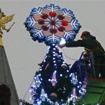 Municipal workers put decorations on a huge Christmas tree in Manezh Square outside the Kremlin in Moscow, Wednesday, Dec. 3, 2008. A double headed eagle is seen on the roof of the State Historical Museum. (AP Photo/Mikhail Metzel)