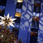 People look on from office windows as the Rockefeller Center Christmas tree stands lit during the 76th annual lighting ceremony Wednesday, Dec. 3, 2008, in New York. (AP Photo/Jason DeCrow)