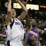 Dallas Mavericks forward Dirk Nowitzki (41,) of Germany, attempts a shot over Phoenix Suns guard Raja Bell, lower right, as forward Amare Stoudemire, upper right, defends in the first half of an NBA basketball game in Dallas, Thursday, Dec. 4, 2008. (AP Photo/Tony Gutierrez)