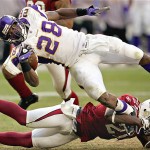Minnesota Vikings runningback Adrian Peterson (28) jumps for extra yards as Arizona Cardinals' Antrel Rolle trips him up during the third quarter of an NFL football game Sunday, Dec. 14, 2008 in Glendale, Ariz. (AP Photo/Matt York)