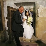 Palestinian bride Sandy walks with her father through a door inside the Church of Nativity, believed by many to be the birthplace of Jesus Christ, during her wedding ceremony in the West Bank town of Bethlehem, Tuesday, Dec. 23, 2008. The biblical West Bank town is readying to greet thousands of tourists for Christmas celebrations. (AP Photo/Muhammed Muheisen)
